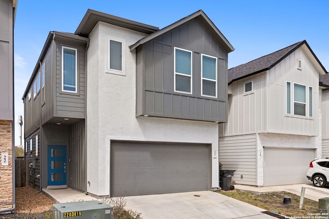 view of front facade with stucco siding, board and batten siding, driveway, and a garage