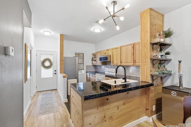 kitchen featuring tasteful backsplash, stainless steel microwave, light brown cabinetry, white electric stove, and a sink