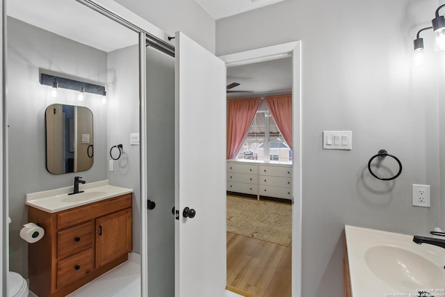 bathroom featuring toilet, wood finished floors, and vanity