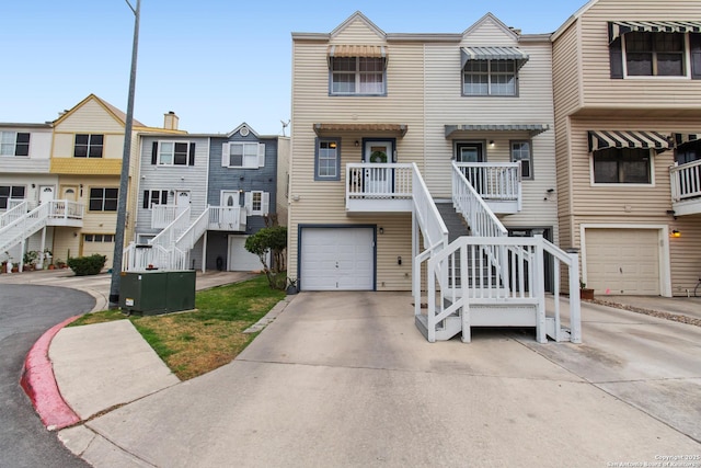 townhome / multi-family property with cooling unit, concrete driveway, stairs, and a garage