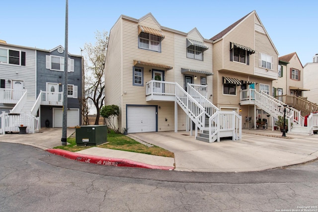 multi unit property with a garage, driveway, and stairway