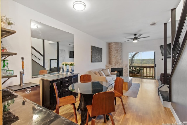 dining space with stairs, light wood-type flooring, visible vents, and ceiling fan