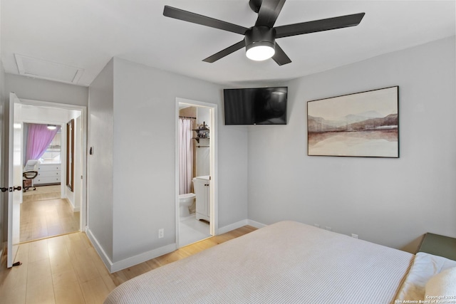 bedroom with a ceiling fan, baseboards, light wood-type flooring, and connected bathroom