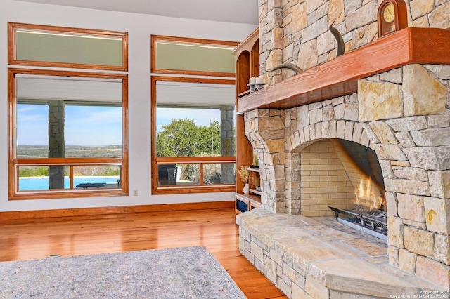 living area with baseboards, a healthy amount of sunlight, and wood finished floors