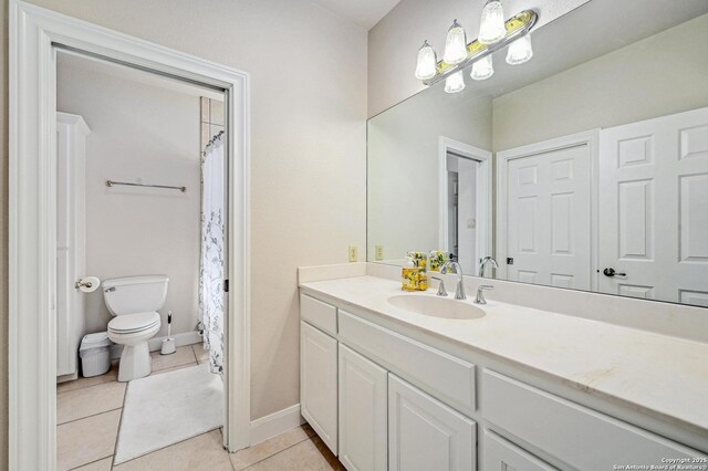 bathroom featuring tile patterned floors, baseboards, toilet, and vanity