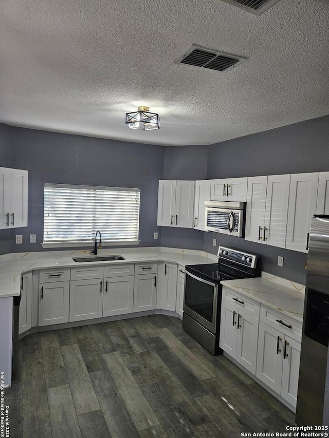 kitchen featuring a sink, visible vents, appliances with stainless steel finishes, and white cabinets