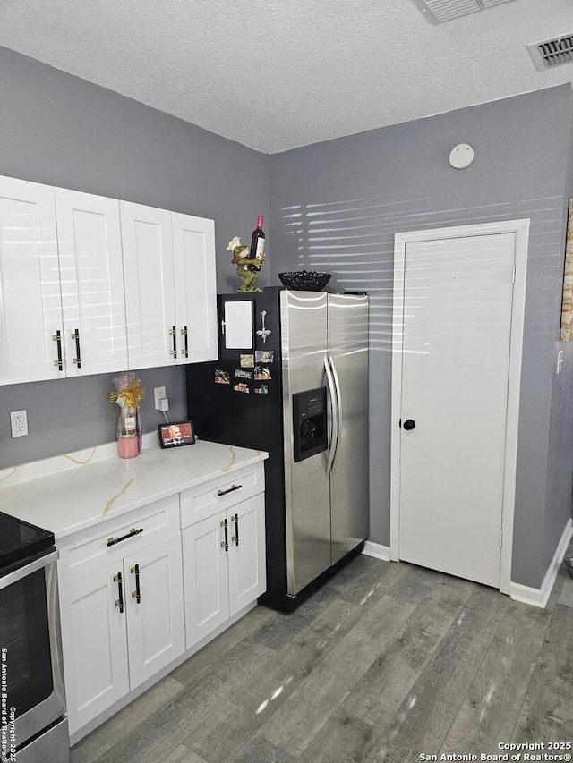 kitchen featuring white cabinetry, light wood-style flooring, visible vents, and stainless steel appliances