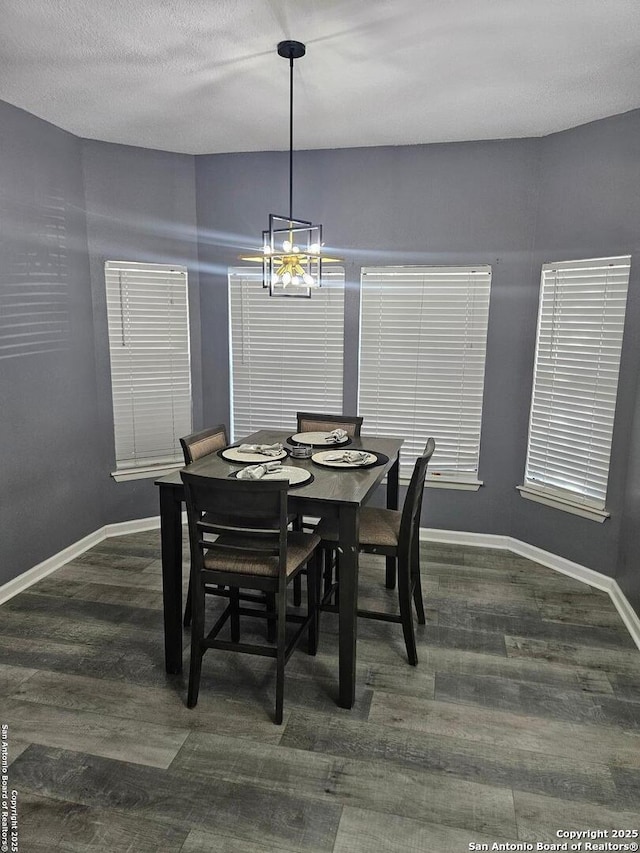 dining room with an inviting chandelier, a textured ceiling, baseboards, and dark wood-style flooring