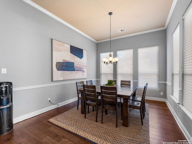 dining area with visible vents, crown molding, baseboards, an inviting chandelier, and wood finished floors