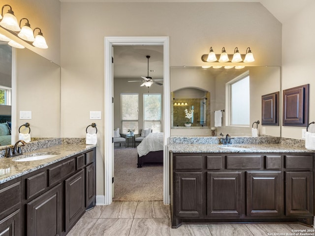 ensuite bathroom featuring connected bathroom, two vanities, a ceiling fan, and a sink