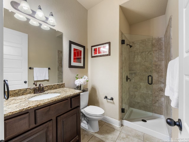 bathroom featuring toilet, a shower stall, tile patterned flooring, baseboards, and vanity