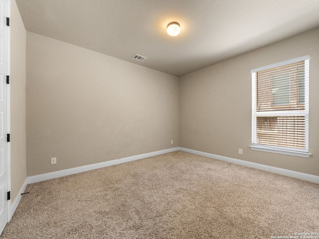 unfurnished room featuring visible vents, baseboards, and carpet