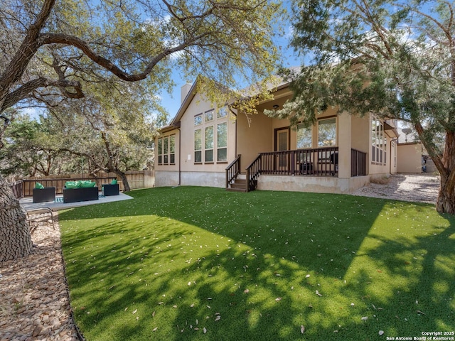 back of house with fence, stucco siding, a lawn, a chimney, and outdoor lounge area