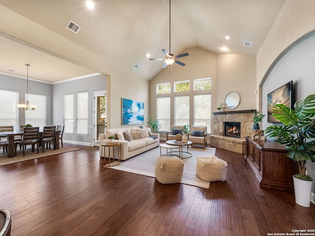 living area with visible vents, high vaulted ceiling, ceiling fan with notable chandelier, a fireplace, and dark wood-style flooring