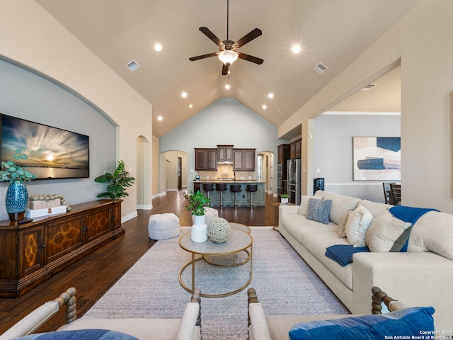 living room with visible vents, a ceiling fan, arched walkways, and dark wood-style flooring