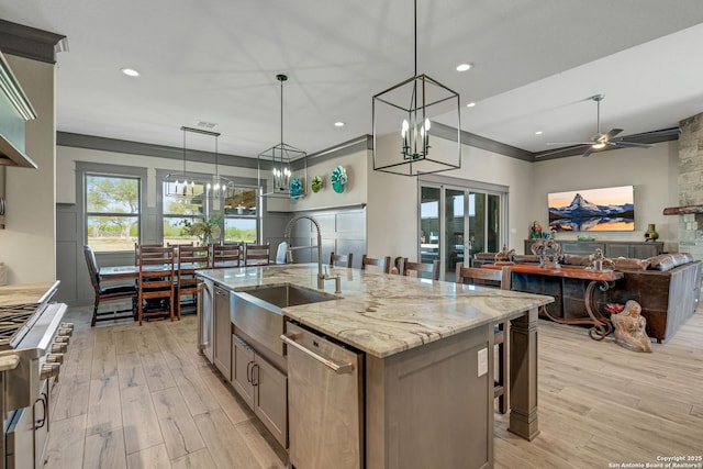 kitchen with a sink, stove, stainless steel dishwasher, and light wood-style flooring