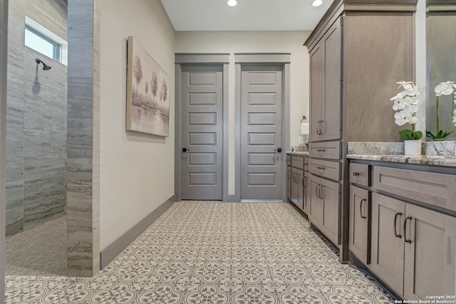 bathroom with vanity, recessed lighting, a walk in shower, and baseboards