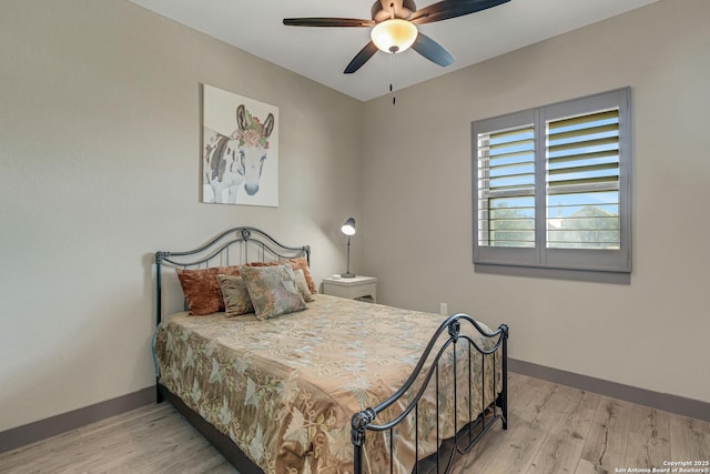 bedroom with wood finished floors, baseboards, and ceiling fan