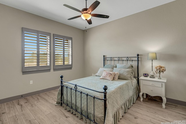 bedroom with ceiling fan, baseboards, and light wood-style flooring