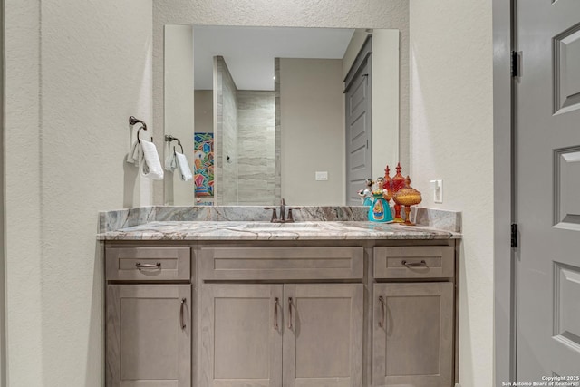 bathroom featuring vanity and a textured wall