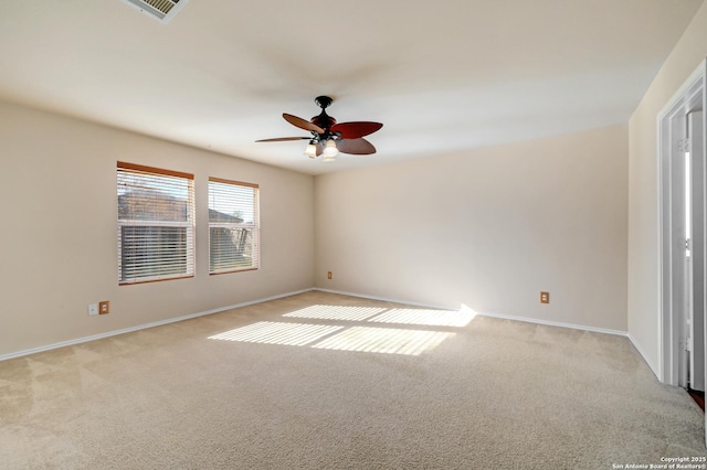 spare room with baseboards, light carpet, visible vents, and ceiling fan