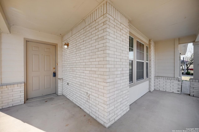 doorway to property featuring brick siding