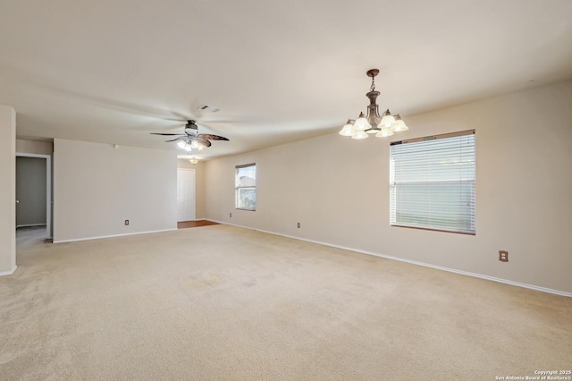 spare room with visible vents, light colored carpet, ceiling fan with notable chandelier, and baseboards