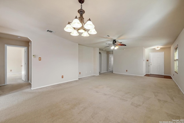 unfurnished living room featuring light carpet, ceiling fan with notable chandelier, visible vents, and arched walkways