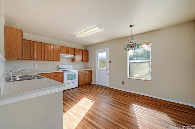 kitchen featuring light wood finished floors, a sink, light countertops, under cabinet range hood, and white electric range