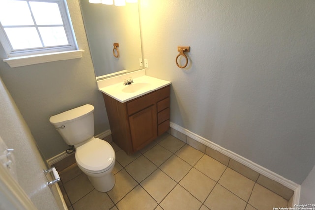 bathroom with tile patterned floors, toilet, vanity, and baseboards