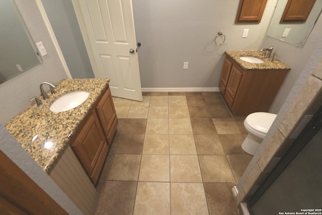 full bathroom with tile patterned floors, two vanities, baseboards, and a sink