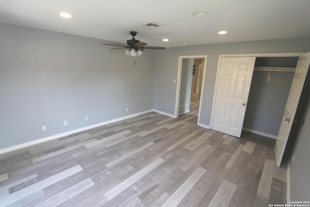 unfurnished bedroom featuring visible vents, wood finished floors, recessed lighting, a closet, and baseboards