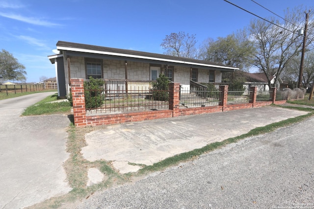 view of front of home with a fenced front yard and stone siding