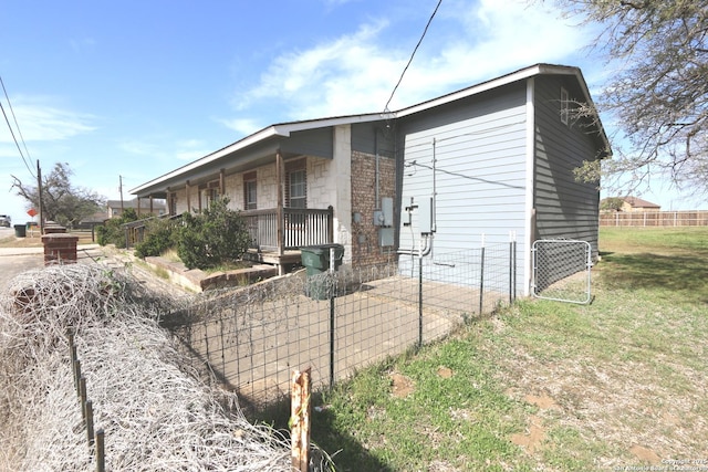 view of side of property featuring fence and covered porch