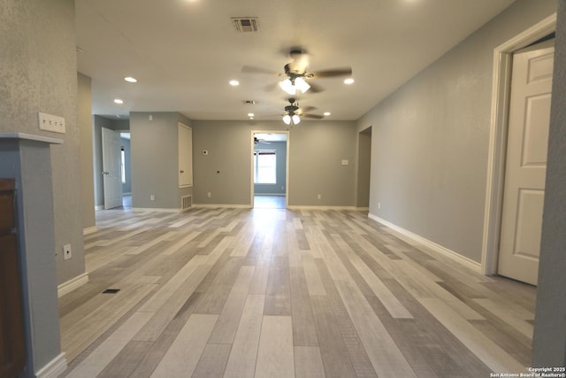 unfurnished room featuring visible vents, light wood-style flooring, baseboards, and a ceiling fan