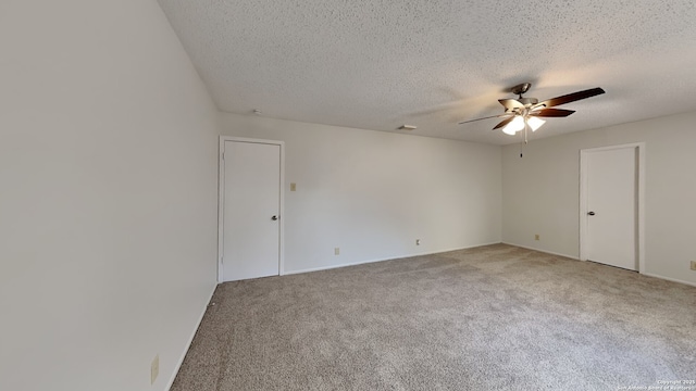 unfurnished room with visible vents, carpet floors, a textured ceiling, and ceiling fan