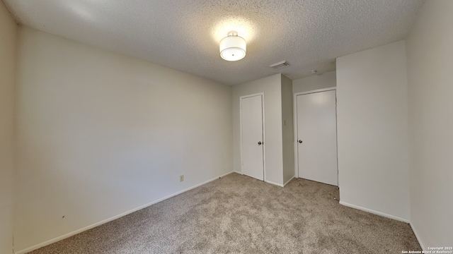 unfurnished bedroom with visible vents, baseboards, light carpet, a closet, and a textured ceiling