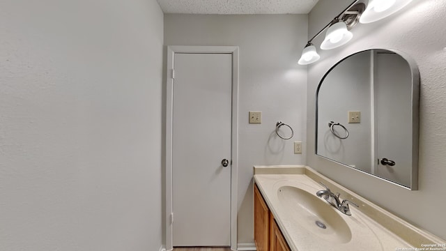 bathroom featuring a textured ceiling and vanity