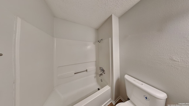 bathroom with bathtub / shower combination, toilet, a textured wall, and a textured ceiling