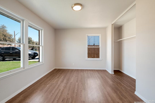 unfurnished bedroom with a closet, baseboards, and wood finished floors