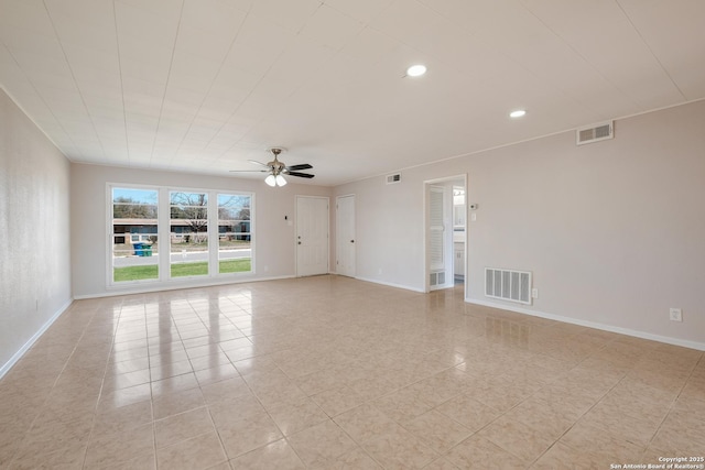 empty room featuring baseboards, visible vents, and ceiling fan