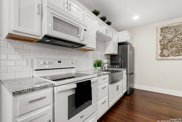 kitchen with a sink, tasteful backsplash, dark wood-style floors, white appliances, and baseboards