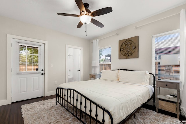 bedroom with ceiling fan, baseboards, dark wood-style floors, and ensuite bathroom