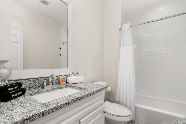 bathroom with visible vents, toilet, vanity, and shower / tub combo