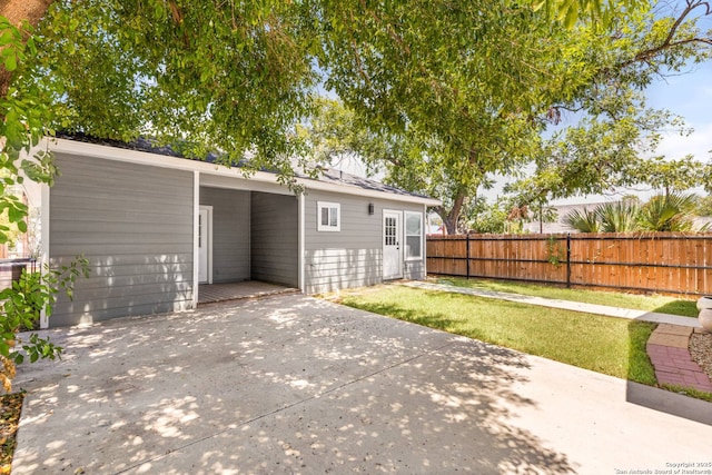 rear view of property with a patio area, a lawn, and fence