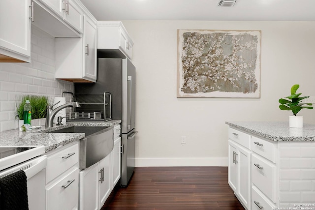 kitchen featuring dark wood-type flooring, a sink, tasteful backsplash, baseboards, and light stone countertops