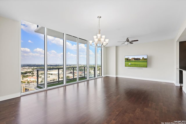 spare room with expansive windows, baseboards, wood finished floors, and ceiling fan with notable chandelier