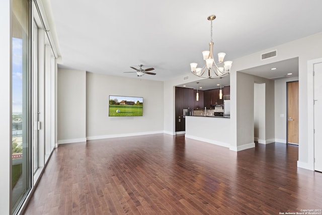 unfurnished living room featuring visible vents, baseboards, dark wood-type flooring, and ceiling fan with notable chandelier