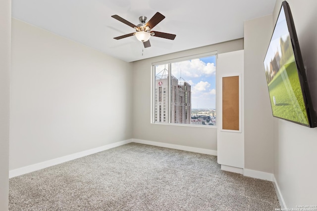 unfurnished room with baseboards, carpet, and a ceiling fan