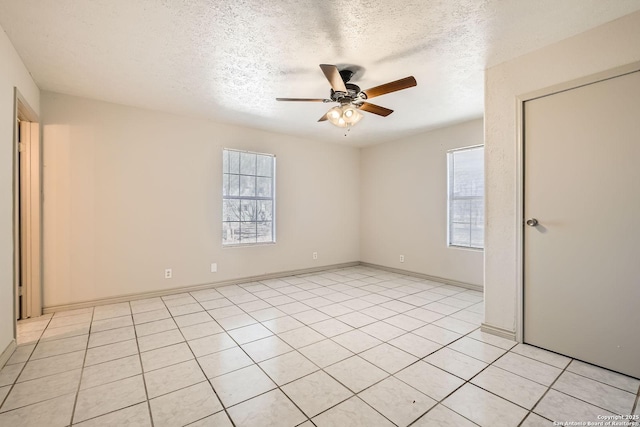 unfurnished room featuring a wealth of natural light, a textured ceiling, ceiling fan, and light tile patterned flooring